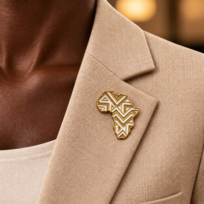 Broche Renaissance Ébène Olà en forme de carte d'Afrique dorée et ivoire épinglée sur un blazer beige