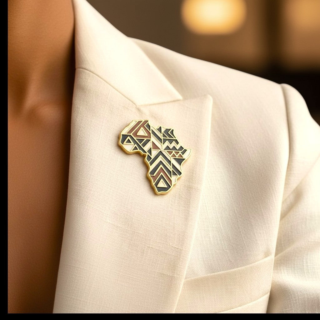 Broche Renaissance Ébène Sankofa en forme de carte d'Afrique avec motifs géométriques sur un blazer blanc